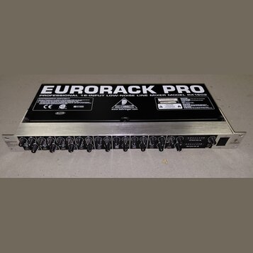 Stříbrný rackový mixér s černým horním krytem. Na krytu je velký bílý nápis EURORACK PRO a text PROFESSIONAL 16-INPUT LOW-NOISE LINE MIXER MODEL RX16…
