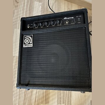 Černý basový kombozesilovač s texturovaným povrchem a černou přední síťovkou. Na horním ovládacím panelu je nápis Ampeg BA-108 a ovládací prvky s pop…