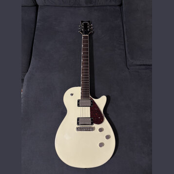 Bílá elektrická kytara s tvarem připomínajícím Les Paul a tmavým hmatníkem. Na hlavě je nápis KRAETEN. Nástroj má dva humbuckery, tmavě červený plech…