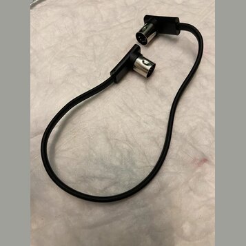 Černý kabel s dvěma konektory typu XLR. Oba konektory mají kovové hroty a černé plastové kryty. Na kabelu ani konektorech nejsou viditelné žádné znač…