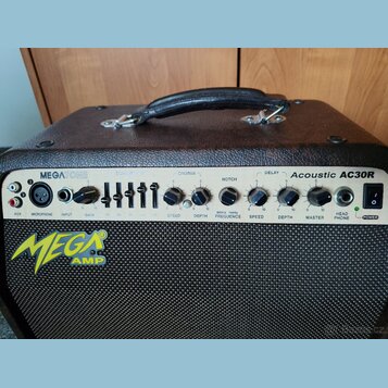Kytarový kombozesilovač v hnědém vinylovém potahu s černou textilní maskou. Na ovládacím panelu jsou nápisy MEGATONE a Acoustic AC30R, vlevo dole je…
