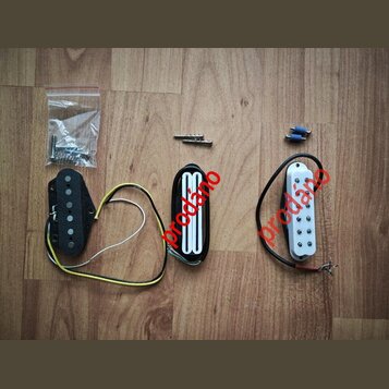 Tři kytarové snímače v různých provedeních: jeden černý s jedním řadou pólů, jeden černý humbucker s bílými cívkami a jeden bílý s jednou řadou pólů.…