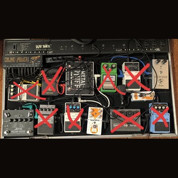 Fotografie znázorňuje efektový pedalboard v černém kufru značky Warwick. Na desce je umístěno několik kytarových efektů, včetně značek Joyo (model PR…