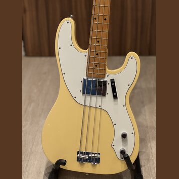 Krémově bílá elektrická basová kytara s bílým pickguardem a hnedým hmatníkem ze dřeva. Na chromovaném krytu snímače je viditelné logo "Gretsch". Nást…