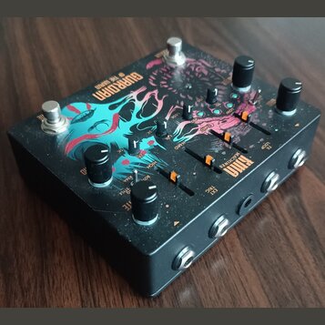 Černý efekt pedál s barevným grafickým motivem v modrých a růžových odstínech. Na horní ploše je nápis GURRDORN OF THE DARKN a logo KYMA MACHINES. Za…