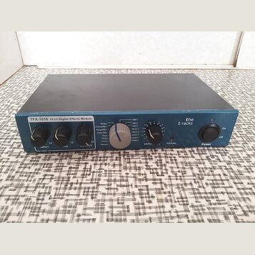 Modrý efektový modul s nápisem TFX-1016 18 bit Digital Effects Module a logem the t.racks. Přední panel obsahuje tři černé otočné ovladače s popisky…