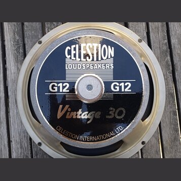 Kruhové reproduktory s černým krytem a stříbrným rámem. Na krytu jsou bílý nápis CELESTION LOUDSPEAKERS, zlatý nápis Vintage 30 a dvakrát bílý nápis…