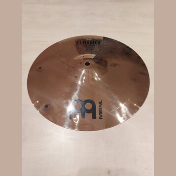 Kruhový mosazný činel s Injuries povrchem. V horní části je nápis CLASSICS CUSTOM a ve spodní části logo MEINL s doprovodným grafickým symbolem. Povr…