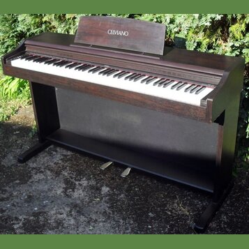 Digitální piano v tmavě hnědé dřevěné provedení s černým spodním panelem. Na horním stojáku na noty je bílý nápis CELVIANO a vpravo nad klávesami je…
