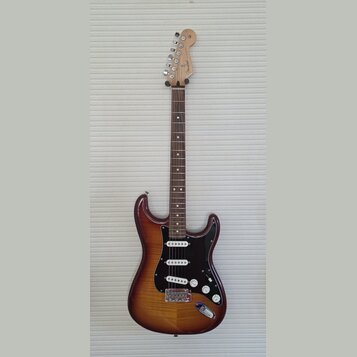 Elektrická kytara s trupem v hnědém sunburst provedení a černým pickguardem. Na hlavě hmatníku je viditelné logo "Squier". Nástroj má tři snímače typ…