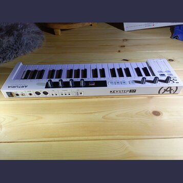 Bílá klaviatura s 37 klávesami. Na přední hraně je nápis KEYSTEP 37 a pod ním text CONTROLLER & SEQUENCER, v pravém rohu je logo (A.). Vlevo na horní…