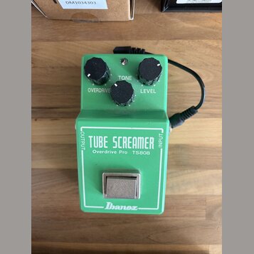 Zelený efekt pedál s nápisy TUBE SCREAMER, Overdrive Pro TS808 a logem Ibanez. Na horní straně jsou tři černé ovládací knoflíky s popisky OVERDRIVE,…