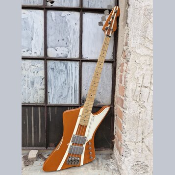 Hnědá elektrická basová kytara s bílým pickguardem a světlou hnedou hmatníkem. Na těle je vidět nápis "Eagle" a dva humbuckery s kovovými kryty. Lak…
