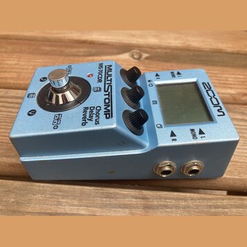 Modrý kytarový efekt s kovovým šasi. Na horní straně je nápis MULTISTOMP a model MS-70CDR, dále text Chorus Delay Reverb. Zařízení má jeden stoupací…