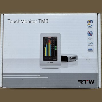 Krabice s nápisem TouchMonitor TM3 a logem RTW. Na obrázku je zobrazen stříbrný přístroj s displejem, který zobrazuje barevnéy měřiče úrovně a ovláda…