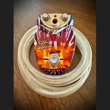 Efekt Talk Box značky Danelectro s barevným motivem tie-dye v červených, žlutých a modrých odstínech. Na horní straně jsou dva otočné oválné knoflíky…