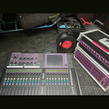 Digitální mixovací pult s nápisem ALLEN&HEATH GLD-80, vybavený faderem, tlačítky a displejem. Vedle pultu jsou dva rackové stageboxy s fialovými pane…