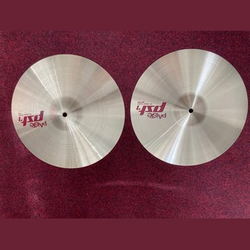 Dva kovové činely v přirozené zlatavé barvě s viditelným broušením povrchu. Na levém činele je nápis „paiste psX 14" HEAVY HI-HAT TOP“. Na pravém čin…