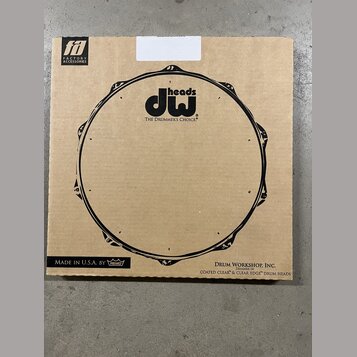 Kartonová krabice s černým potiskem stylizovaného bubnového obruče. Uprostřed je logo „dw heads“ a pod ním nápis „THE DRUMMER'S CHOICE®“. V levém hor…