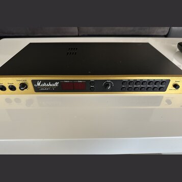 Zlatý rackový předzesilovač s černým krytem. Na čelním panelu je bílé logo Marshall a nápisy VALUE MIDI PRE-AMP JMP-1. Zařízení má červený digitální…