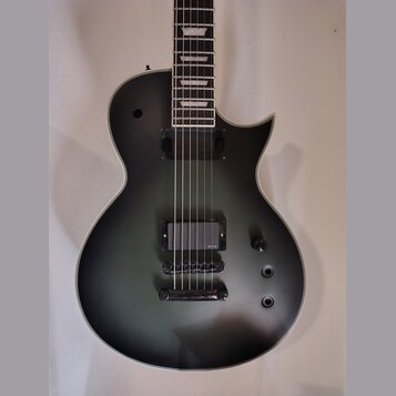 Kytara s matně černým povrchem těla a hnedým hmatníkem s bílými vložkami. Nástroj má dva humbuckery, přičemž na spodním je viditelné logo EMG. Na těl…