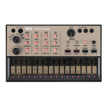 Stříbrošedý syntezátor KORG volca keys. Na horním panelu jsou ovládací prvky s nápisy VCO, VCF, LFO a EG, sekce DELAY a konektory MIDI IN, IN-SYNC-OU…