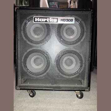 Černý basový reproduktor s kovovou mřížkou, který je osazen čtyřmi membránami. V horní části je umístěno logo Hartke a nápis HD50B. Celý přístroj sto…