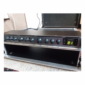 Černý rackový efektový procesor s řadou ovládacích knoflíků a přepínačů. Na panelu jsou viditelné nápisy sekcí INPUT-OUTPUT, MULTIEFFECT, REVERB a PR…