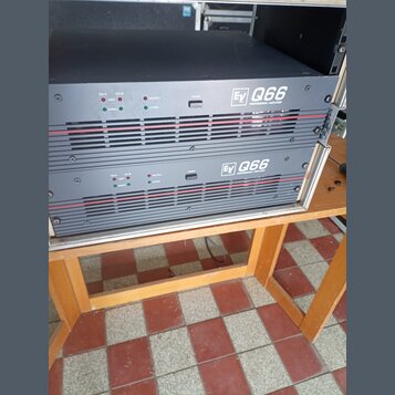 Dvě černé rackové koncové stupně s červenými vodorovnými liniemi na předním panelu. Na obou zařizeních je bílý nápis „Ev Q66 PROFESSIONAL AMPLIFIER“.…