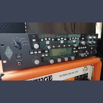 Černý rackový kytarový procesor s nápisem KEMPER a označením PROFILING AMPLIFIER. Přední panel obsahuje řadu tlačítek, otočných ovladačů a centrální…