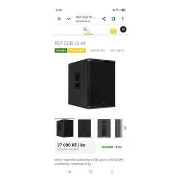 Černý aktivní subwoofer s hranatým tvarem a kovovou ochrannou mřížkou v přední části. Na spodní části mřížky je umístěno malé čtvercové logo RCF. Na…