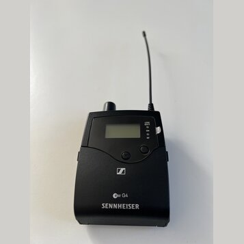Černý bezdrátový vysílač s anténou a malým displejem. Na přední straně jsou nápisy LOW BATT, ON, RF a označení ew G4. Ve spodní části je bílý nápis S…