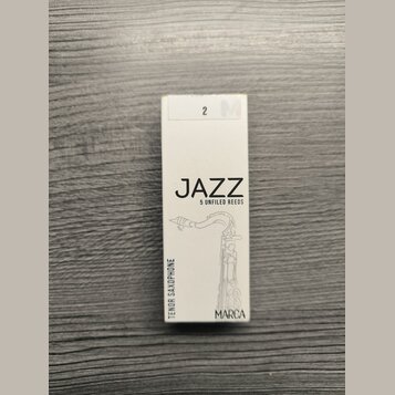 Bílá krabička s trosečatými trsy saxofonu. Na přední straně je černý nápis JAZZ a pod ním text 5 UNFILED REEDS, v dolní části je uvedeno MARCA a svis…