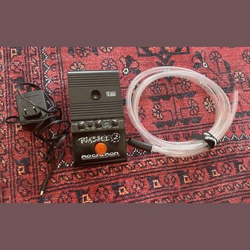 Černý kytarový předzesilovač s nápisy AMPLIFIER TALBOX, BANSHEE 2 a ROCKRON TECHNOLOGY FOR GUITARISTS. Zařízení má několik ovládacích knoflíků, přepí…