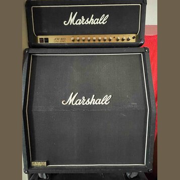 Kytarový kombozesilovač složený z hlavy a boxu značky Marshall. Na hlavě je bílé logo Marshall a nápis JCM 800 LEAD SERIES. Box má černou textilní př…