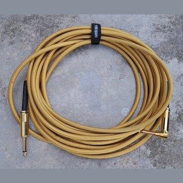 Zlatý pletený instrumentální kabel s konektory v zlatém provedení. Jeden konektor je rovný a druhý pravý. Na černém stahovacím pásku je bílý nápis ER…