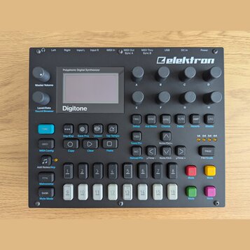 Černý polyfonní digitální syntetizátor s nápisem Elektron v pravém horním rohu a označením Digitone pod displejem. Nad displejem je text Polyphonic D…