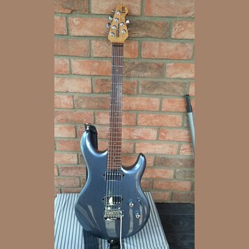 Modře metallic elektrická kytara s hnědým hmatníkem a dřevěnou hlavou. Na hlavě je svisle napsaný nápis Ibanez. Kytara má jeden humbucker u kobylky,…