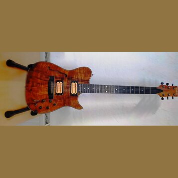 Elektrická kytara s polodupatým tělem v přirozené dřevěné barvě s výraznou masou. Na hlavě hředu je vidět nápis CARVIN. Nástroj má dva humbuckery, hm…