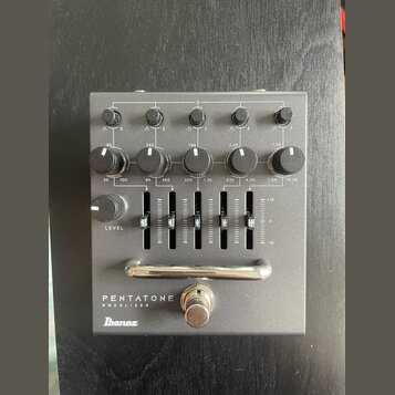 Šedý kytarový efekt s nápisy PENTATONE EQUALIZER a logem Ibanez. Zařízení obsahuje pět otočných knoflíků v horní části, pět knoflíků s označením frek…