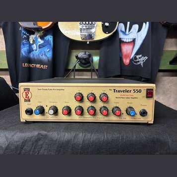 Zlatý basový zesilovač s nápisy EDEN, DAVID EDEN a The Traveler 550. Na předním panelu jsou uvedeny texty Twin Triode Tube Pre Amplifier, World Tour…