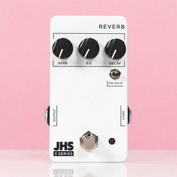 Bílý kytarový efekt s nápisem REVERB. Na horní straně jsou tři černé otočné ovířky s popisy VERB, EQ a DECAY, dále je zde přepínač označený PRE-DELAY…