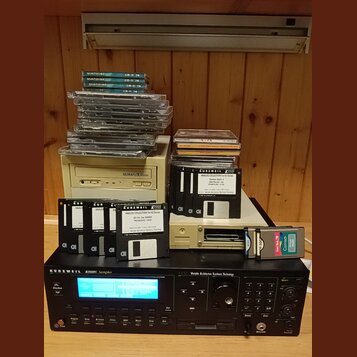 Na fotografii je béžový počítač s nápisem ULTRAFLEX 40Mega a černý rackový sampler značky KURZWEIL, model K2500RS Sampler s nápisem V.A.S.T. Variable…