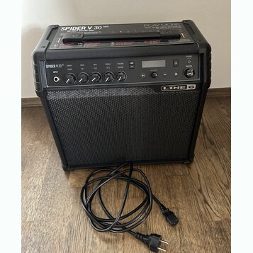 Černý kytarový kombozesilovač značky LINE 6. Na horní části je nápis SPIDER V 30 MkII a text 30-WATT GUITAR AMP, vpravo nápis PLAY MORE. Přední panel…
