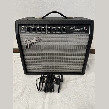 Černý kytarový kombozesilovač s šedou textilní maskou reproduktoru. Na horním ovládacím panelu je nápis Super Champ x2 a VINTAGE MODIFIED TUBE AMPLIF…