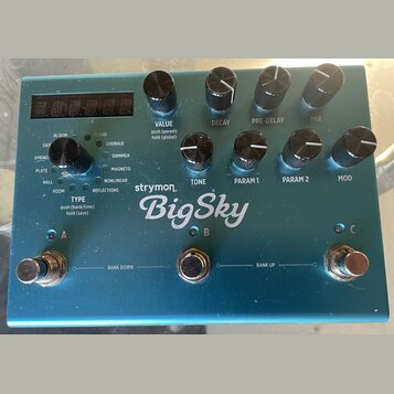 Modré efektové pedál s nápisem strymon BigSky. Horní panel obsahuje čtyři otočné knoflíky s popisky VALUE, DECAY, PRE-DELAY a MIX, spodní řadu čtyř k…