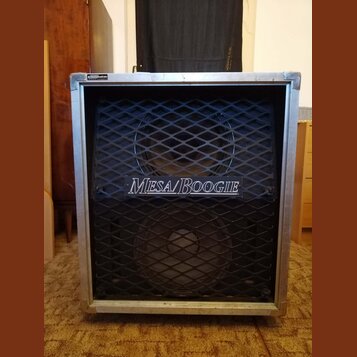 Kytarový reproduktor v hliníkovém rámu s černou mřížkou. Uprostřed mřížky je bílý nápis MESA/BOOGIE. Povrch hliníkového rámu vykazuje drobné oděrky a…