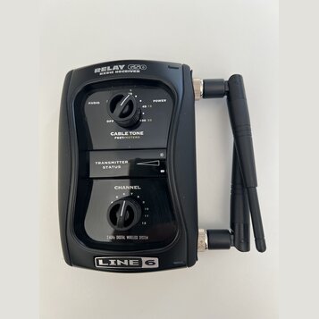 Černý bezdrátový přijímač s dvěma anténami. Na horní části je nápis RELAY G50 RX512 RECEIVER a ve spodní části logo LINE 6. Zařízení obsahuje dva ovr…