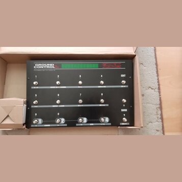 Černý programovatelný MIDI kontrolér s nápisy GROUND CONTROL Pro a Voodoo Lab. Zařízení obsahuje 12 stoupakových spínačů s čísly 1 až 8 a 9 až 4, dis…