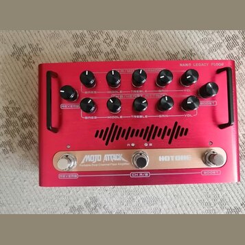 Červený kytarový zesilovač s nápisem NANO LEGACY FLOOR. Na horní straně jsou dvě řady ovládacích potenciometrů s popisky BASS, MIDDLE, TREBLE, GAIN a…